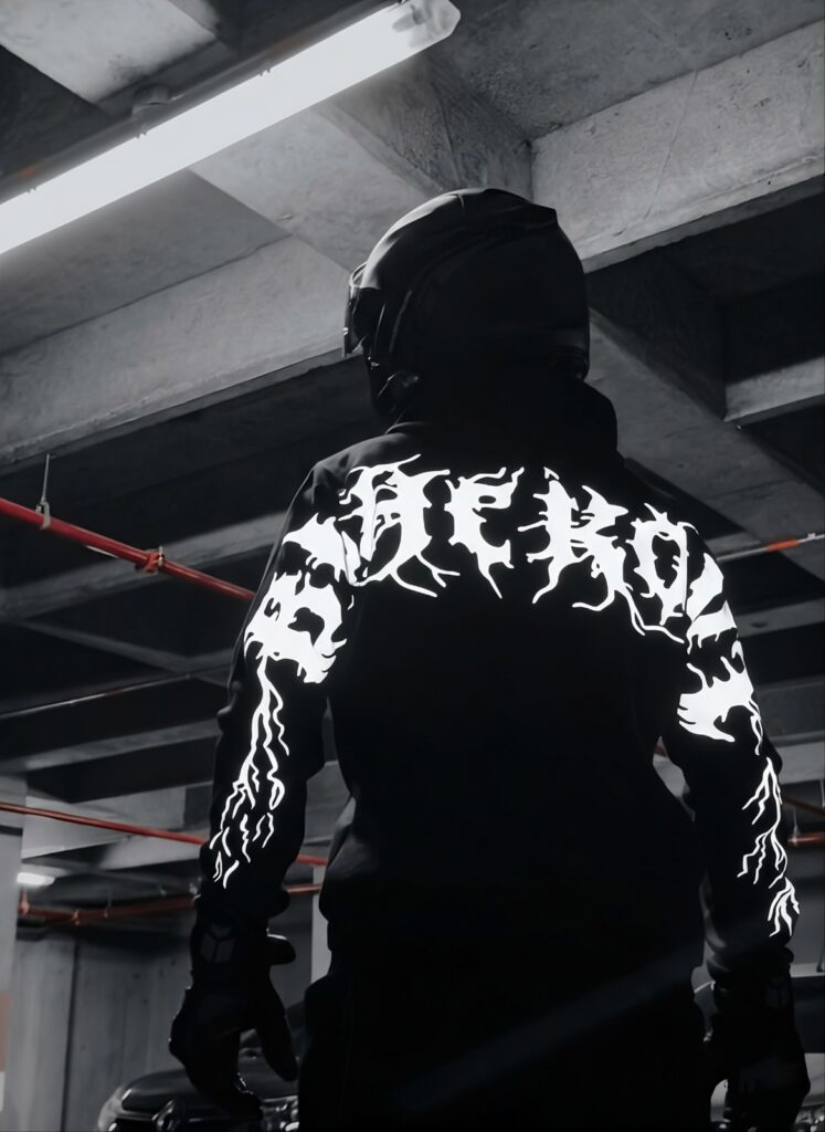 Estampado reflectivo del hoodie Blackout brillando bajo la luz